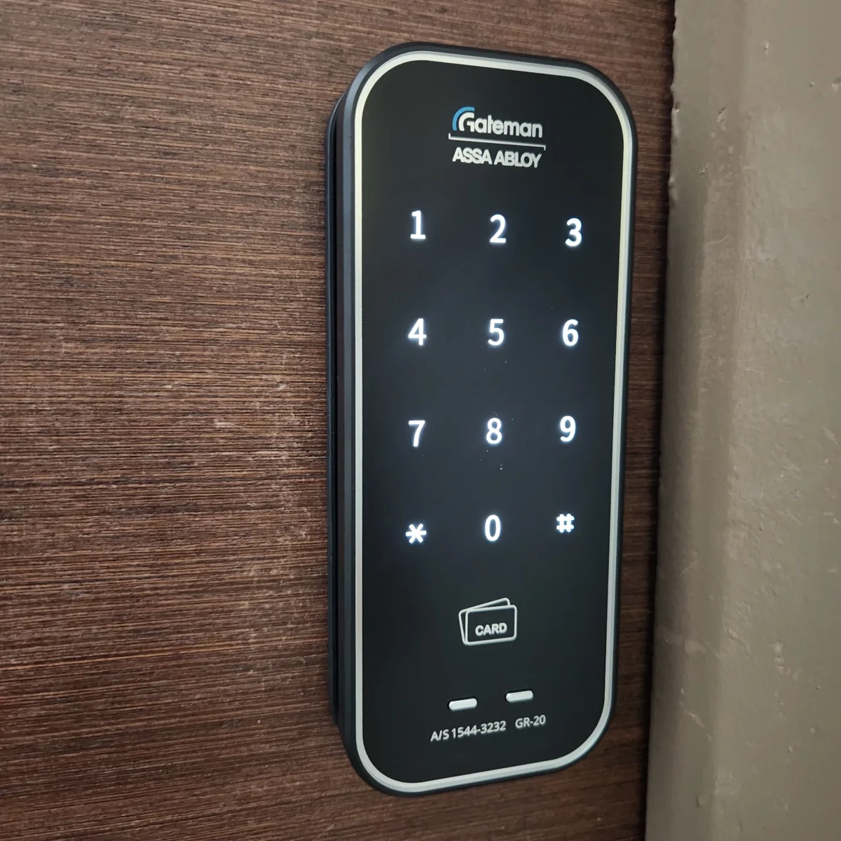 Close-up of a Gateman GR20 Digital Lock with illuminated keypad on a wooden door